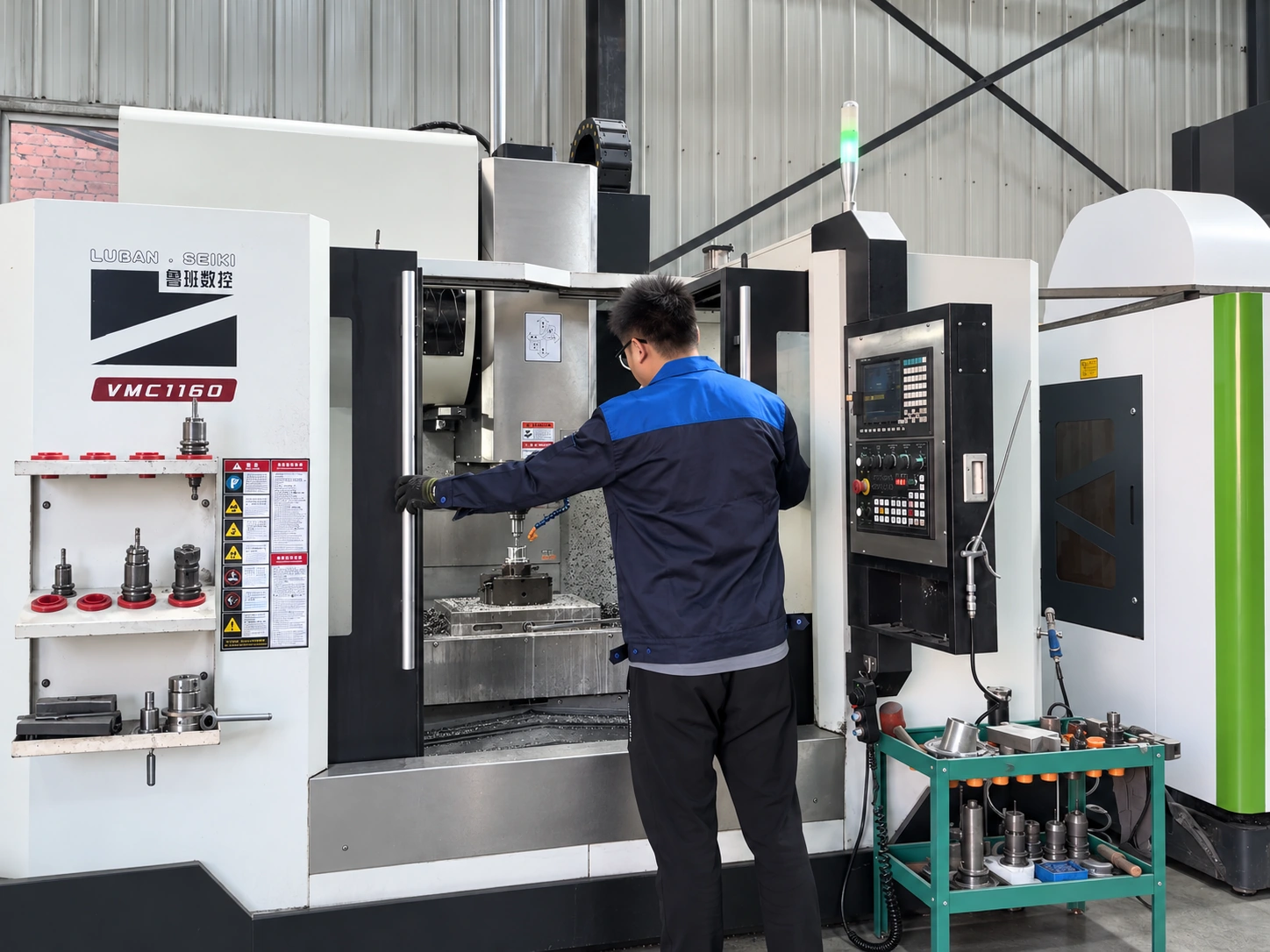 CNC machining setup with an operator, machining center and tool cart.